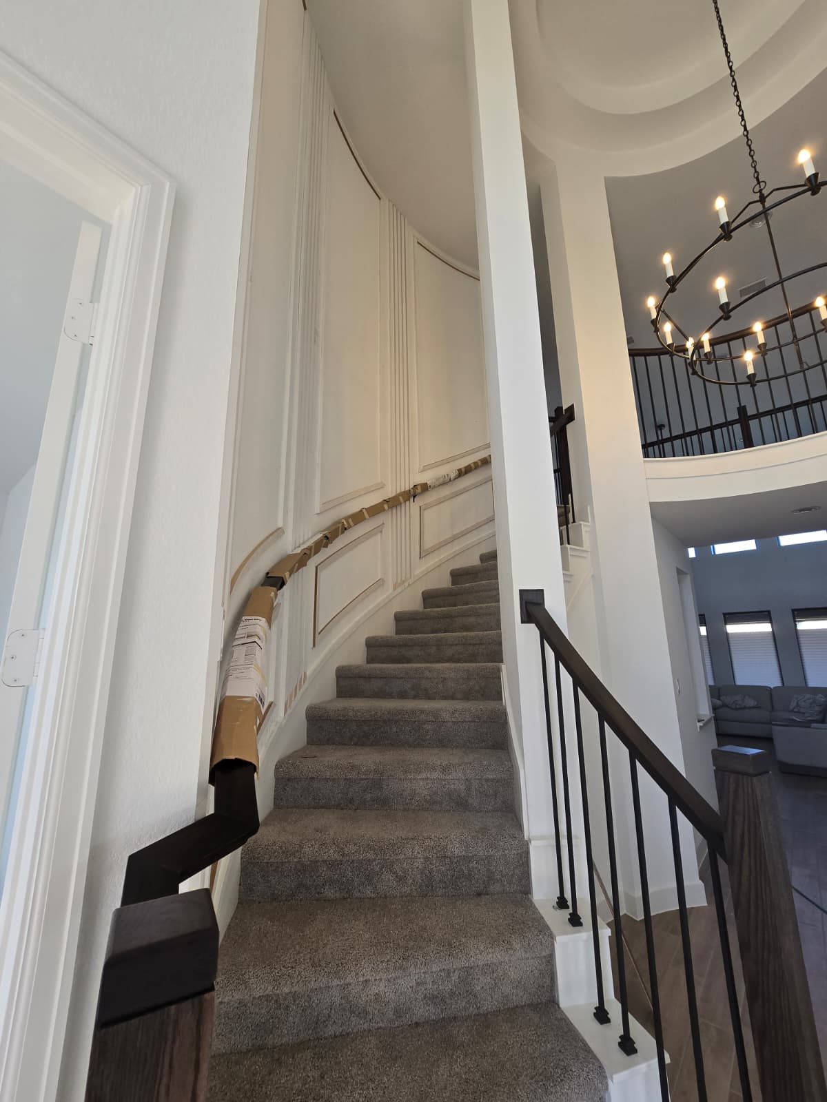 Curved stair molding during finishing with protected handrail.