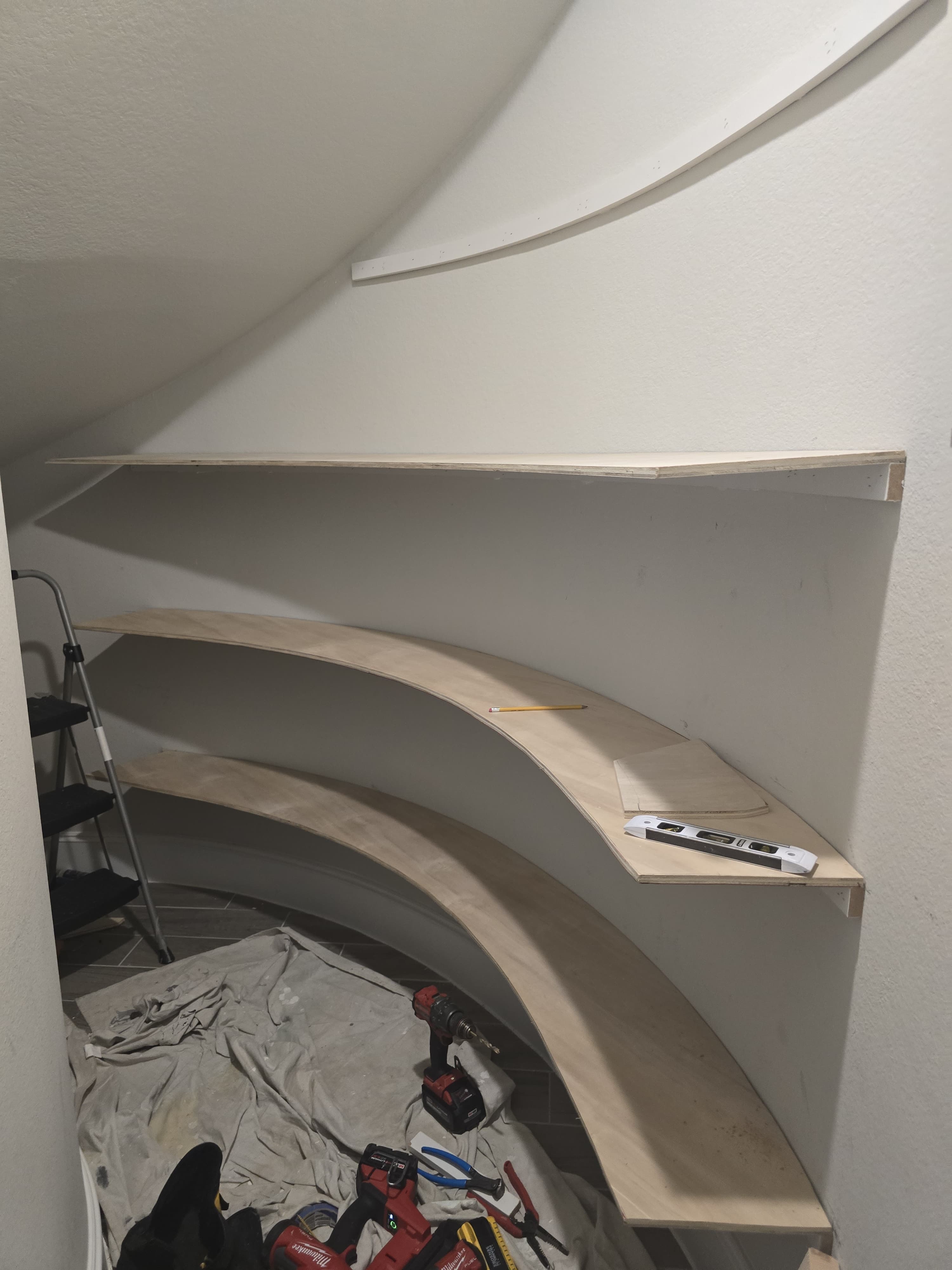 Curved under-stair shelves during installation.