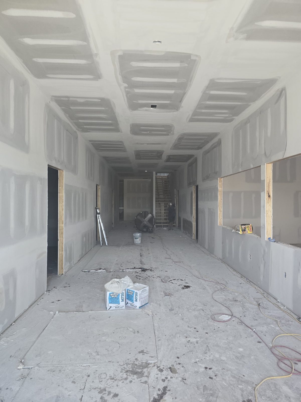 Long hallway drywall taped and mudded during a large repair and finishing project